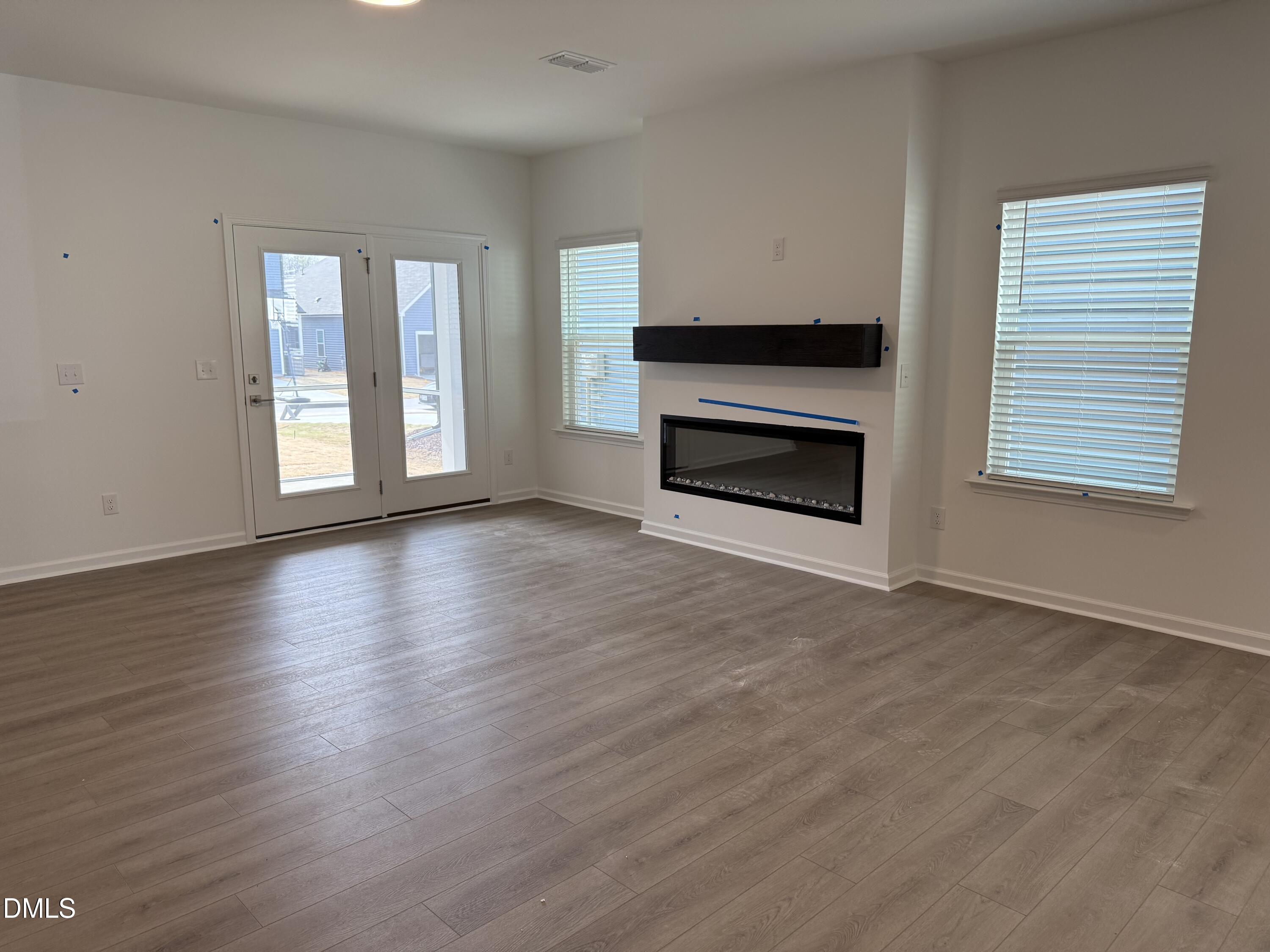 2844 Quarry Road, Unit 173 Rolesville, NC 27571 - Photo 7 of 31 a view of an empty room with wooden floor fireplace and a window
