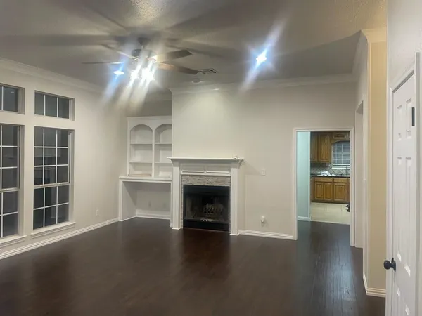 a view of a livingroom with wooden floor and a fireplace