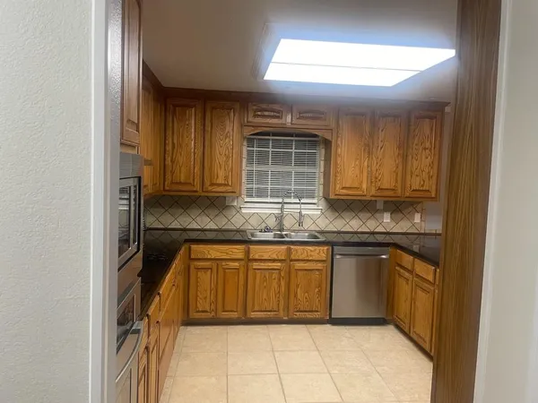 a kitchen with stainless steel appliances granite countertop cabinets and window