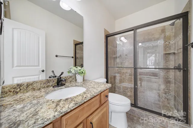 a bathroom with a granite countertop sink toilet and shower