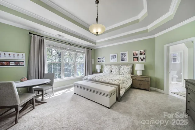 a spacious bedroom with a bed window and flat screen tv