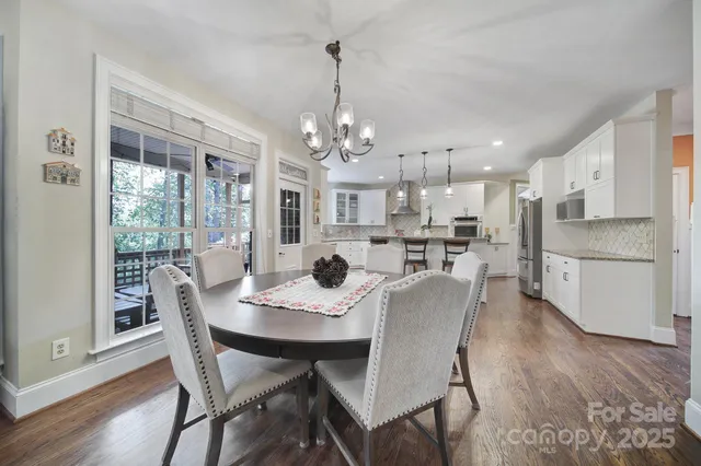 a view of a dining room and livingroom view with furniture wooden floor and chandelier