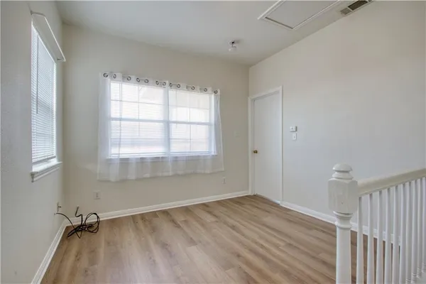 a view of a room with wooden floor and windows