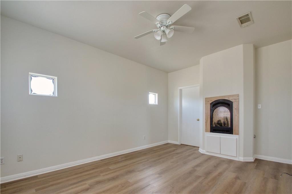 1770 County Road 329 Granger, TX 76530 - Photo 13 of 23 an empty room with wooden floor ceiling fan and window