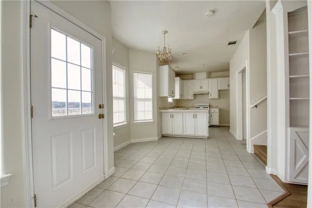 a view of a kitchen with dishwasher and white cabinets