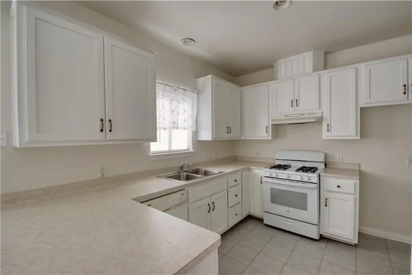 a kitchen with white cabinets stainless steel appliances and sink