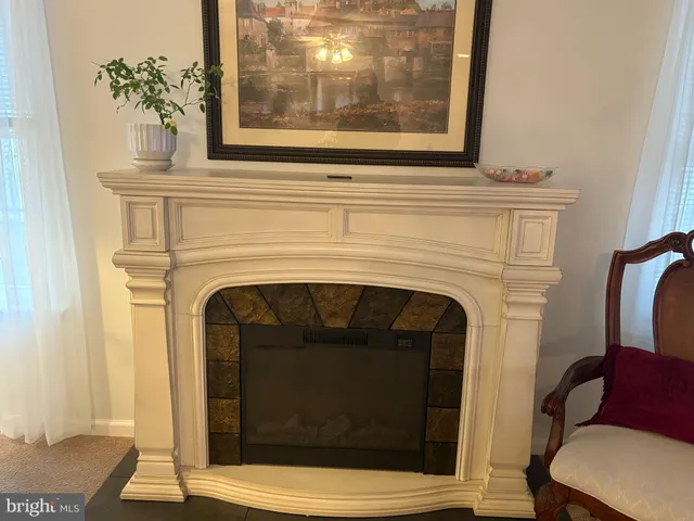 a living room with a fireplace and a potted plant