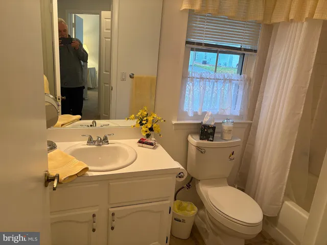 a bathroom with a sink a toilet and mirror