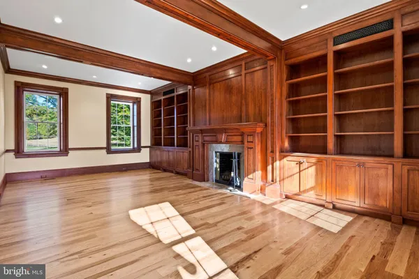 a view of an empty room with window and fire place