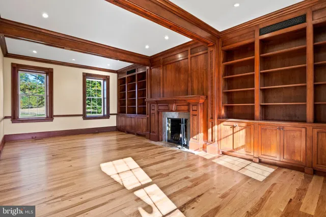 a view of an empty room with window and fire place