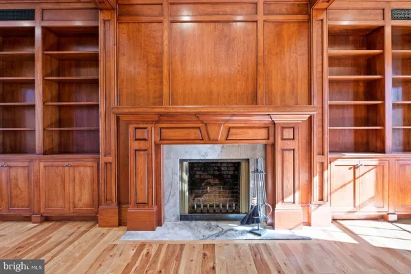 a view of empty room with wooden floor and fireplace