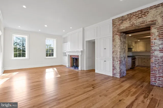 a view of a hallway with wooden floor and entryway