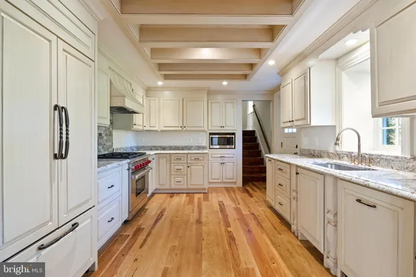 a bathroom with a granite countertop shower a window and a sink