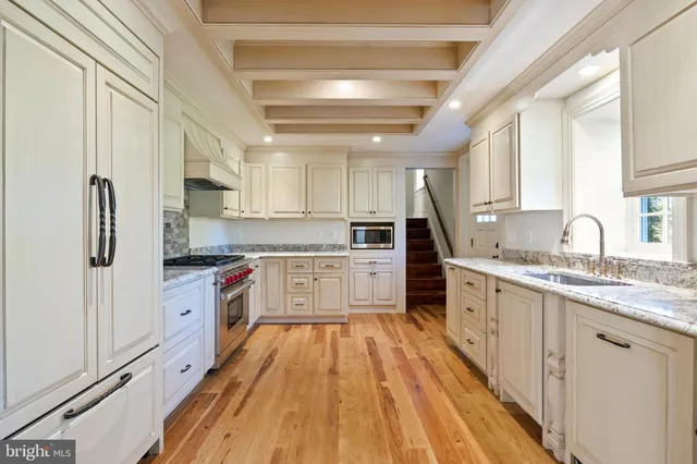a bathroom with a granite countertop shower a window and a sink
