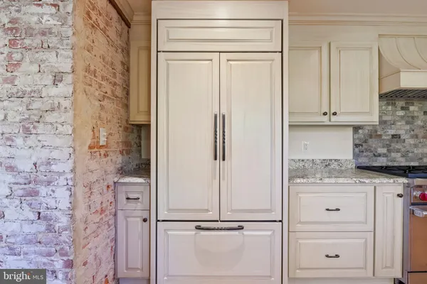 an empty room with wooden floor fireplace and windows