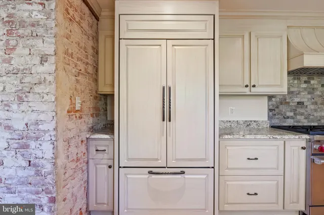 an empty room with wooden floor fireplace and windows