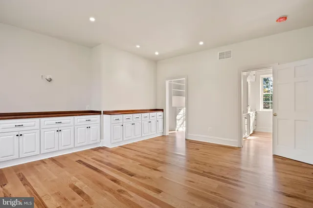 an empty room with wooden floor and window