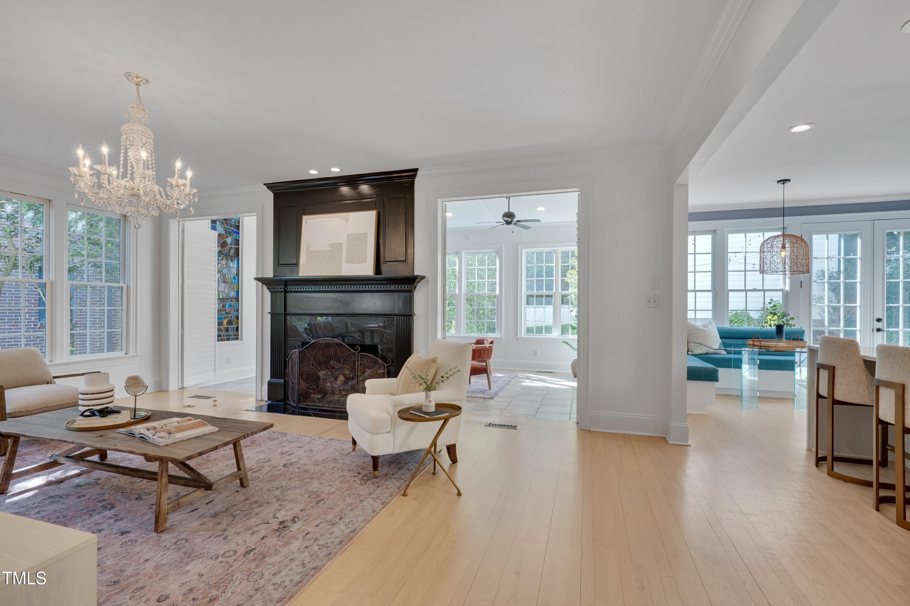 2306 Byrd Street Raleigh, NC 27608 - Photo 13 of 60 a living room with furniture a fireplace and a chandelier