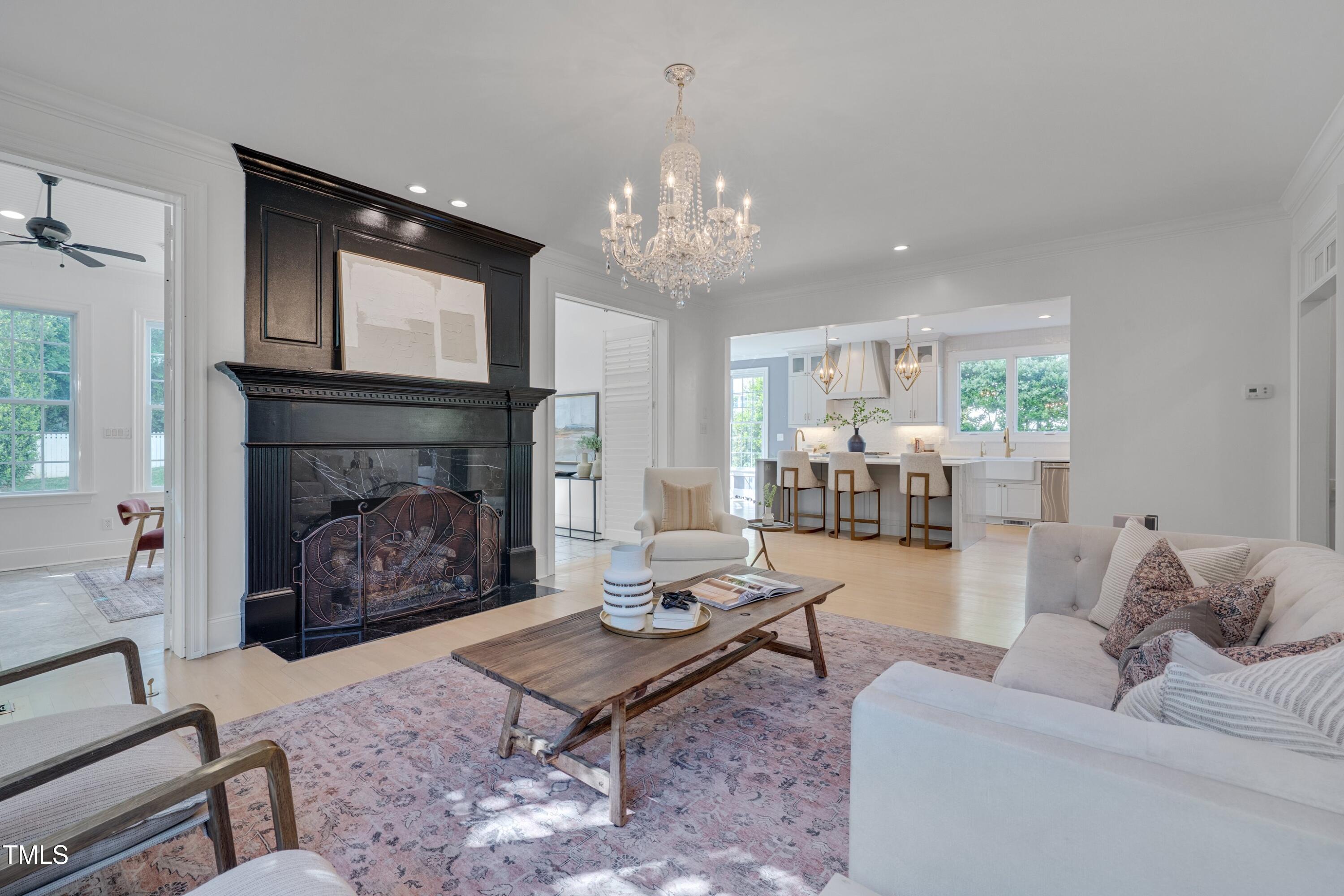 2306 Byrd Street Raleigh, NC 27608 - Photo 15 of 60 a living room with furniture a fireplace and a chandelier