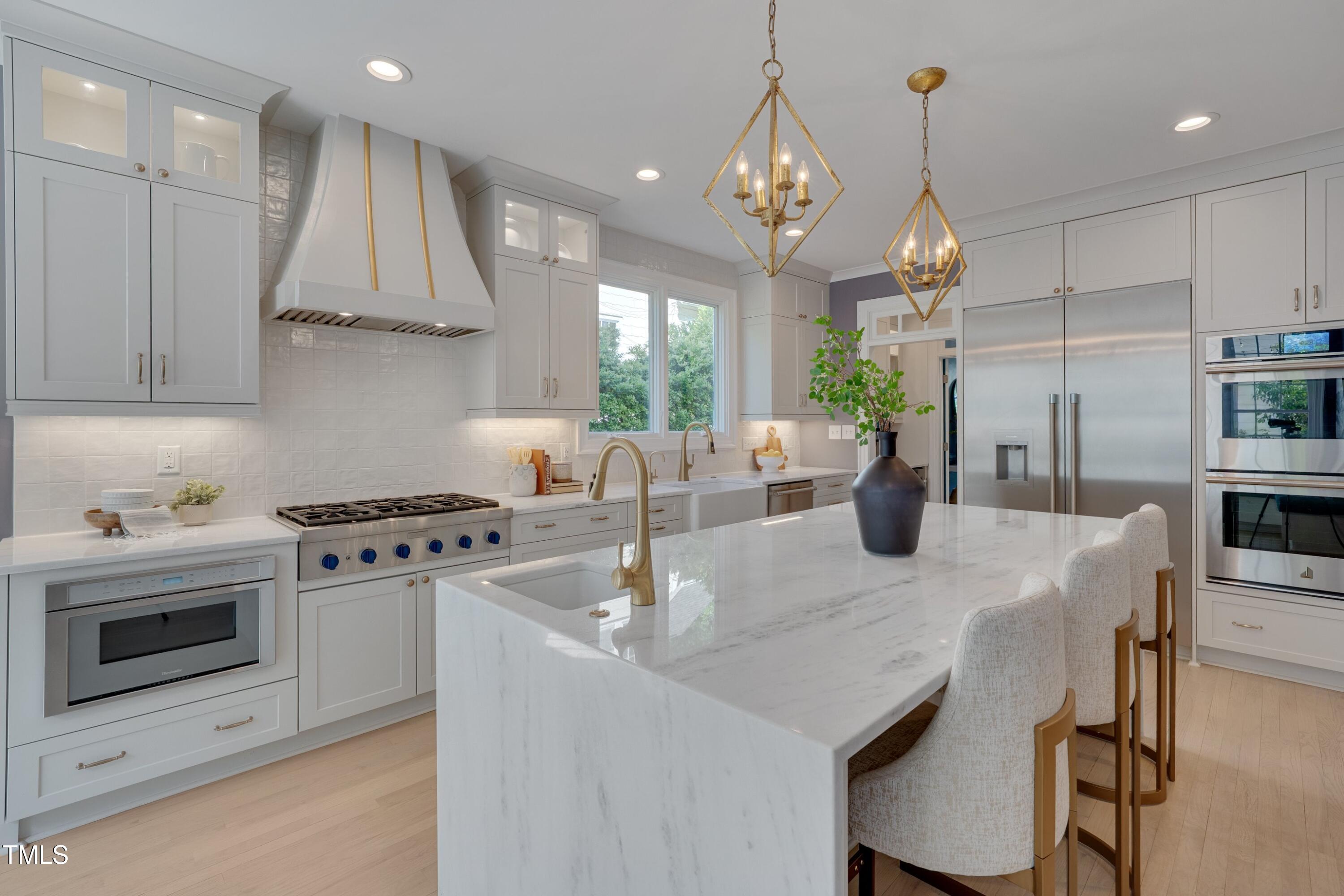 2306 Byrd Street Raleigh, NC 27608 - Photo 21 of 60 a kitchen with kitchen island a stove a table a sink and a refrigerator