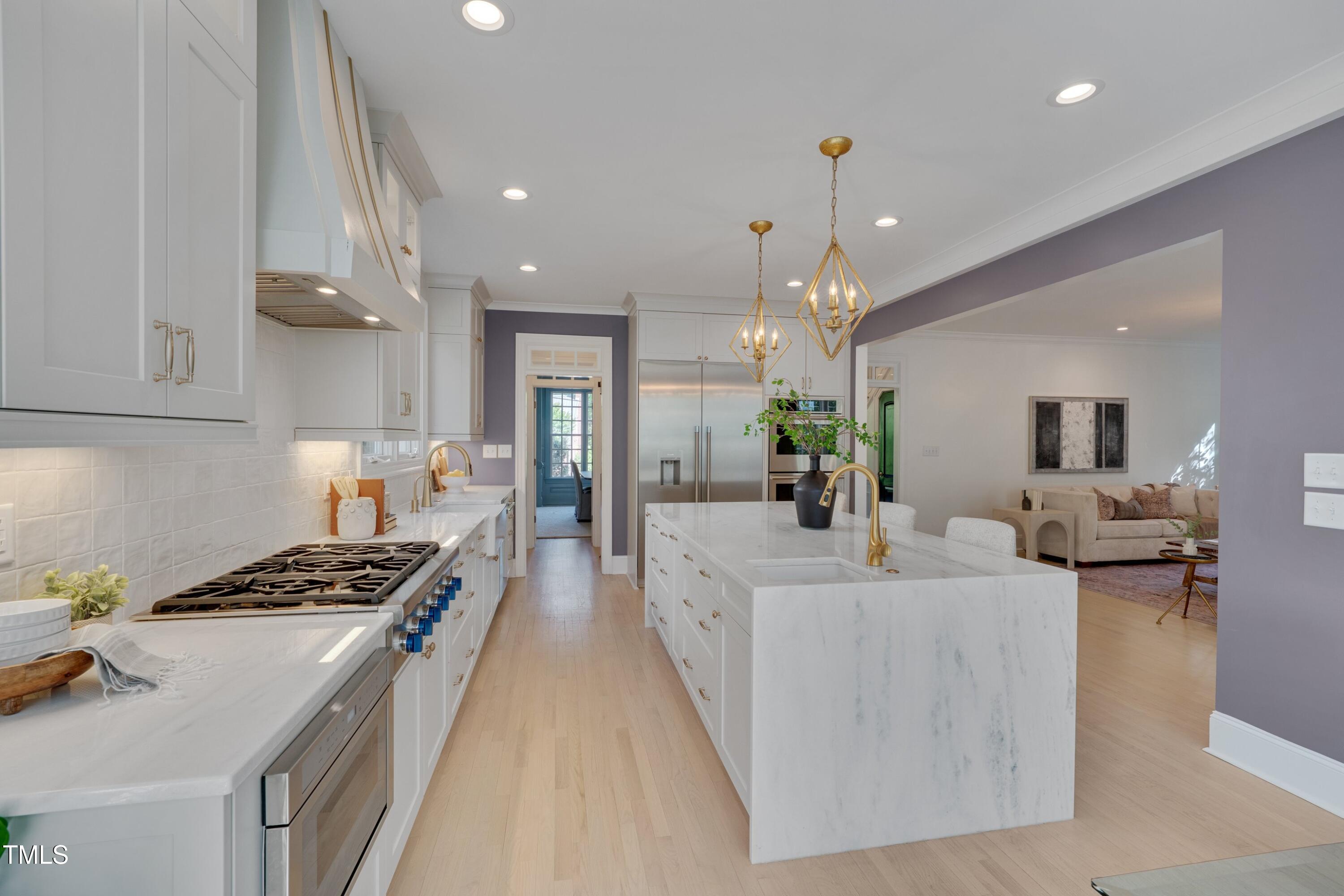 2306 Byrd Street Raleigh, NC 27608 - Photo 22 of 60 a large white kitchen with stainless steel appliances a stove a chimney a sink and a center island