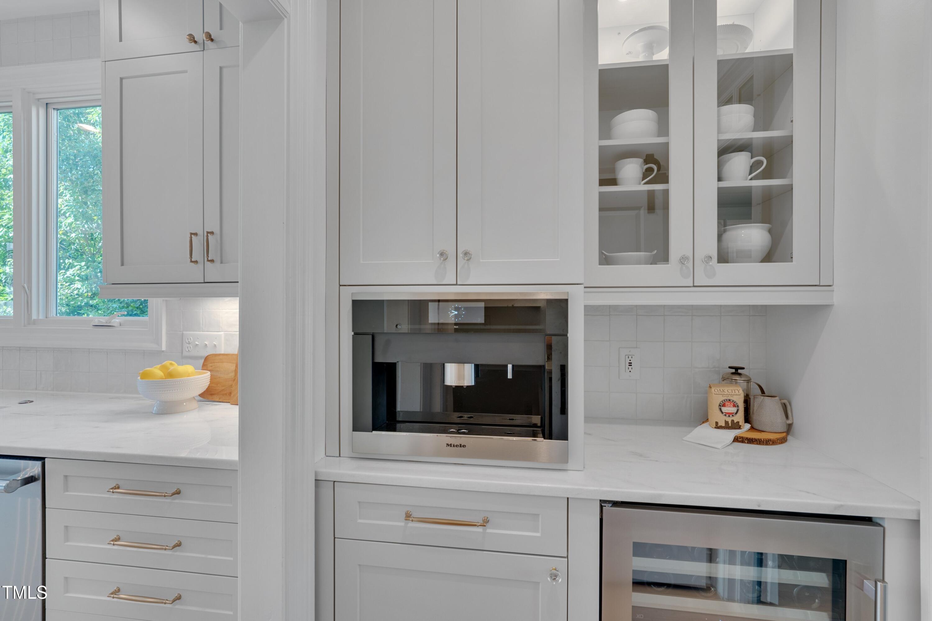 2306 Byrd Street Raleigh, NC 27608 - Photo 29 of 60 a kitchen with white cabinets and a wooden floor