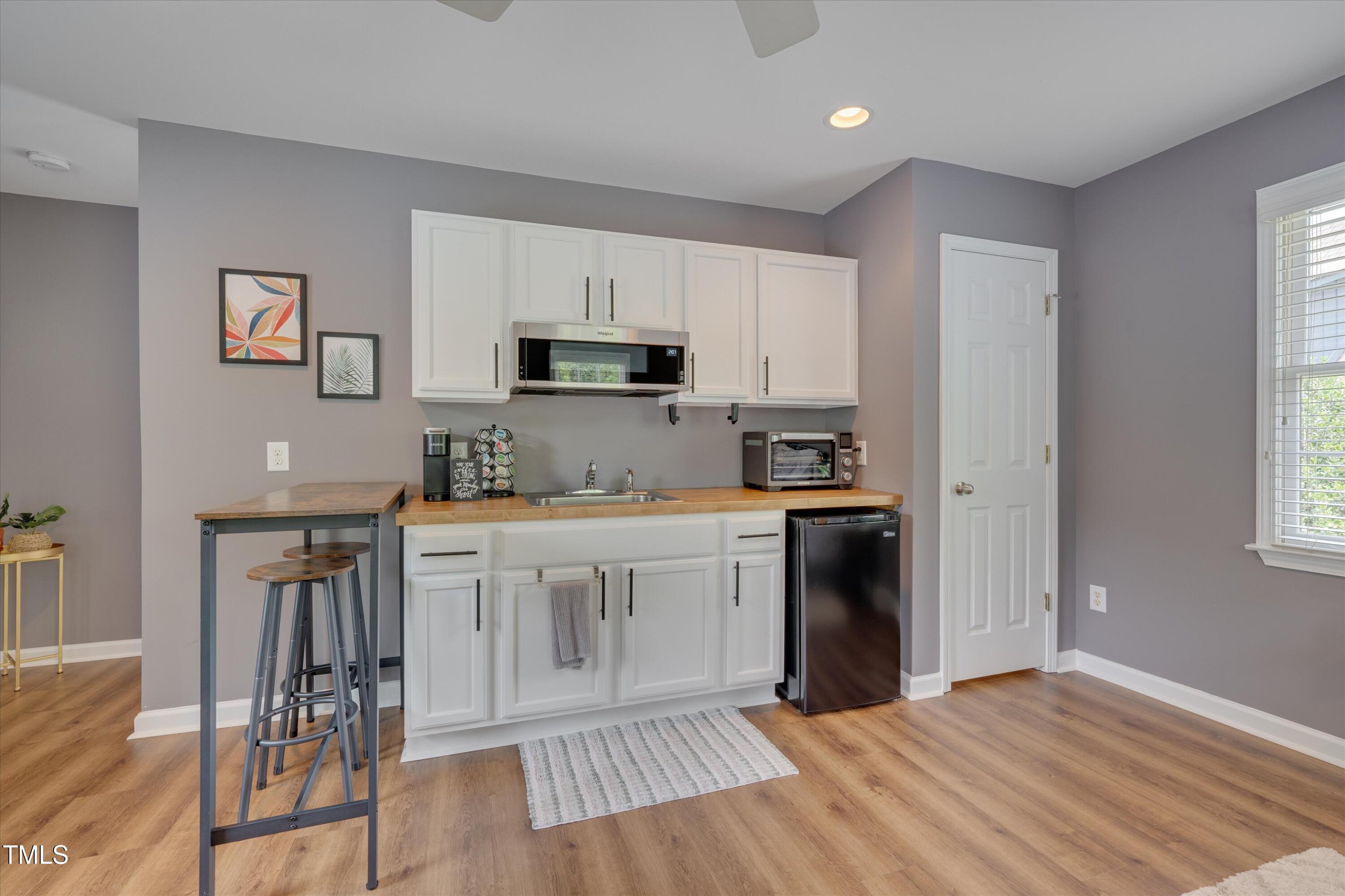 2306 Byrd Street Raleigh, NC 27608 - Photo 52 of 60 a kitchen with a refrigerator stove and white cabinets