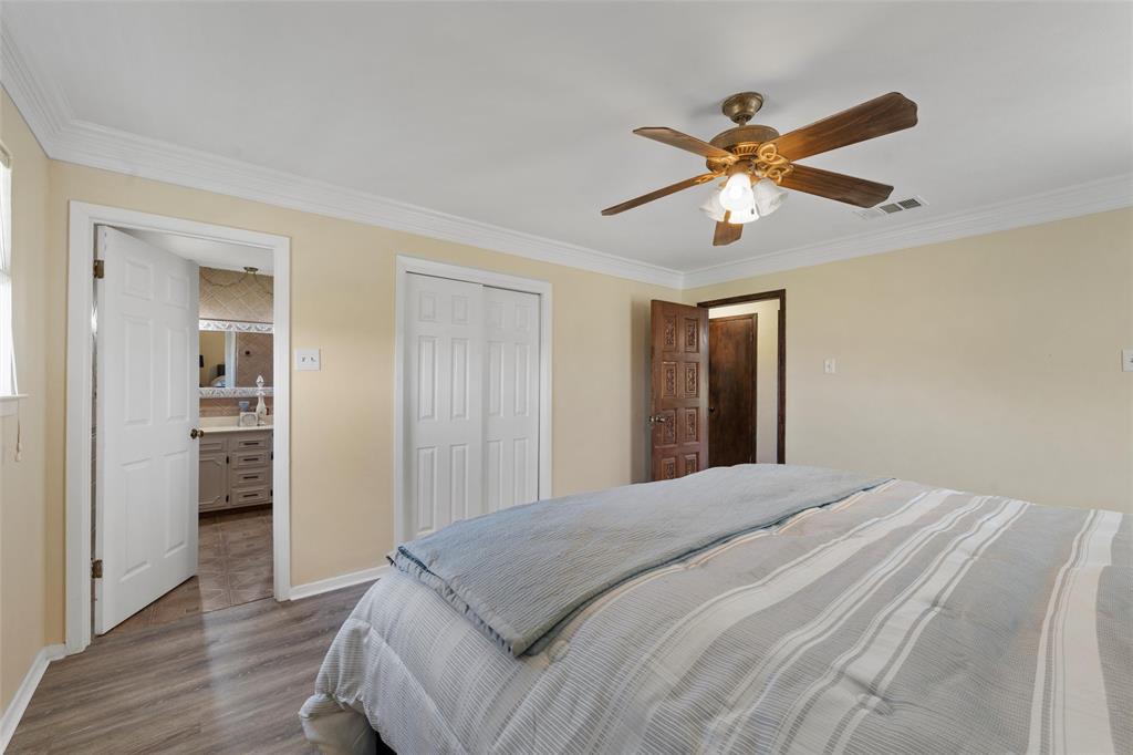3433 West Tours Road West, TX 76691 - Photo 24 of 40 Bedroom featuring connected bathroom, ornamental molding, wood finished floors, ceiling fan, and a closet