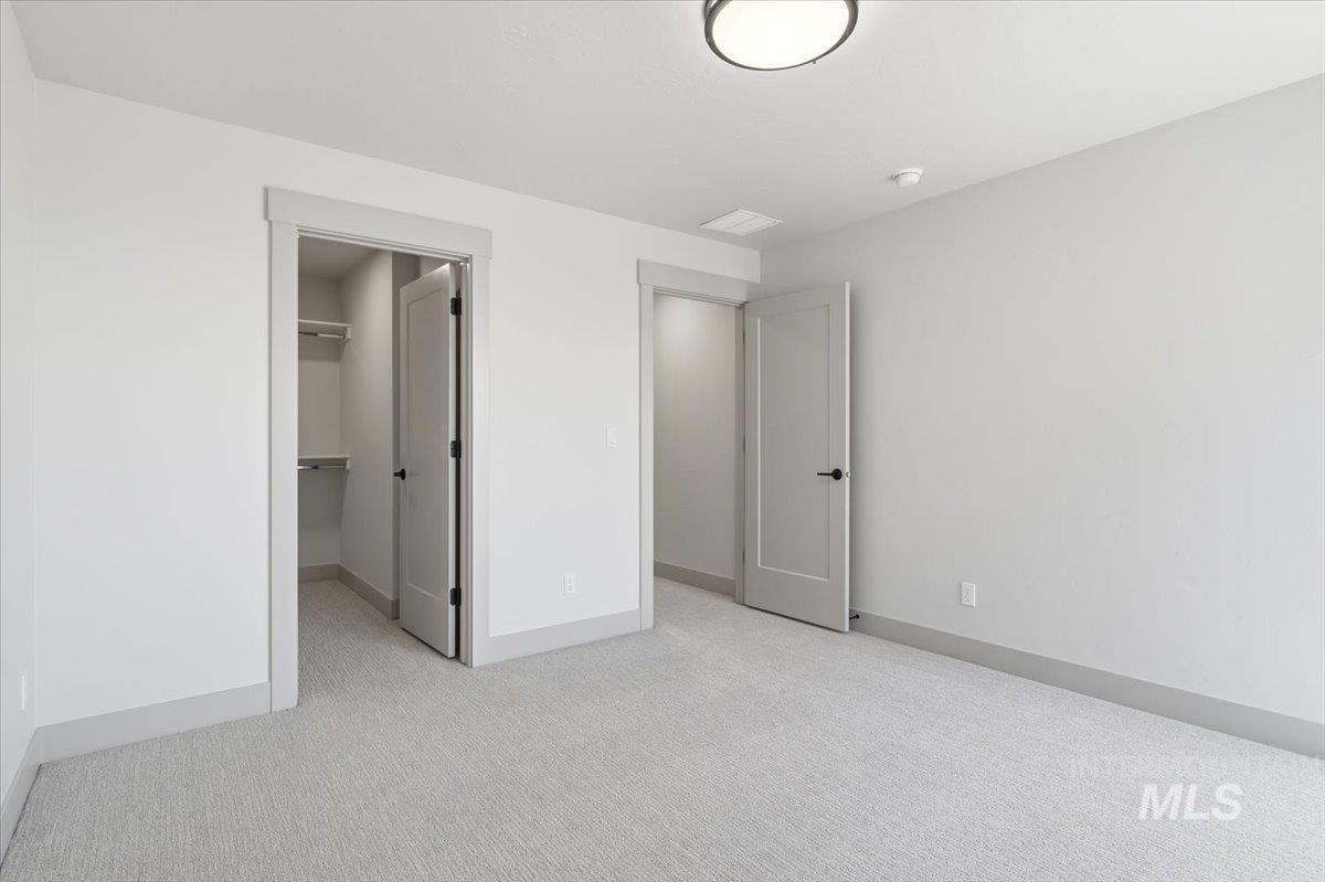 6762 South Messner Way Meridian, ID 83642 - Photo 31 of 35 Neutral-toned room featuring light gray carpet, white walls, and a modern ceiling light fixture