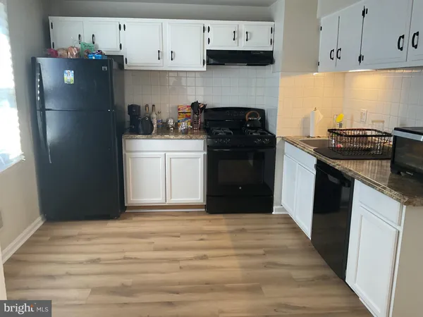 a kitchen with a refrigerator stove and cabinets
