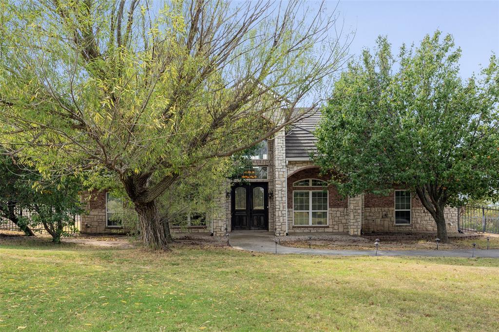 a view of a house with a large tree and a yard