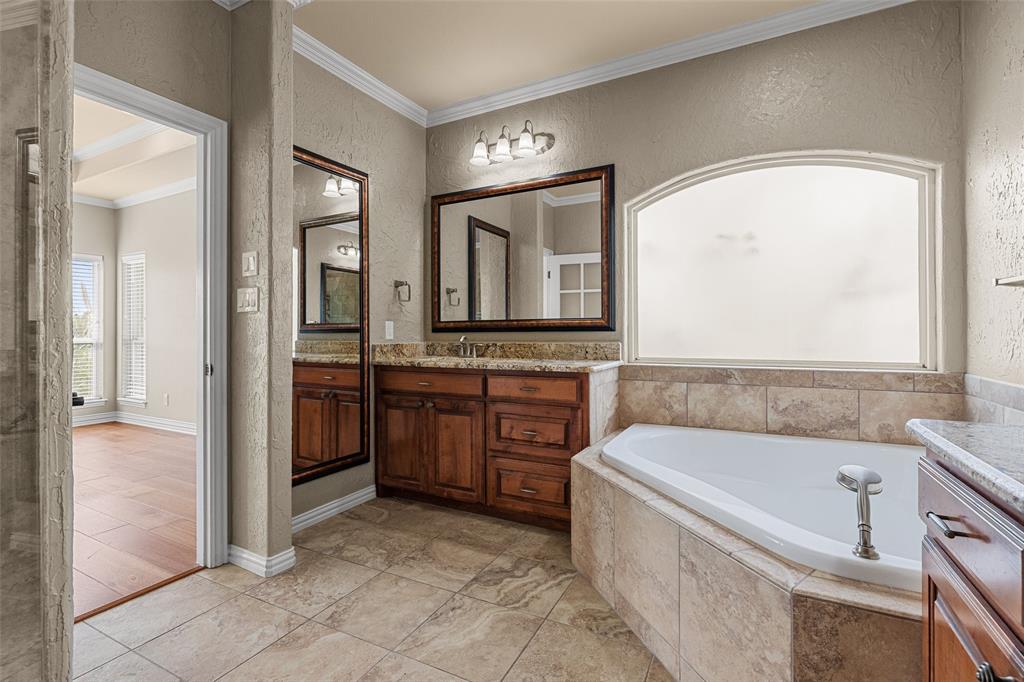 167 Duke Trail Weatherford, TX 76088 - Photo 18 of 40 a bathroom with a tub a sink and mirror