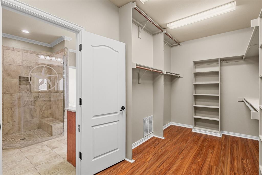 167 Duke Trail Weatherford, TX 76088 - Photo 21 of 40 a view of bathroom with a walk in closet and wooden floor