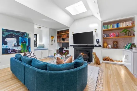 a living room with furniture a flat screen tv and a fireplace