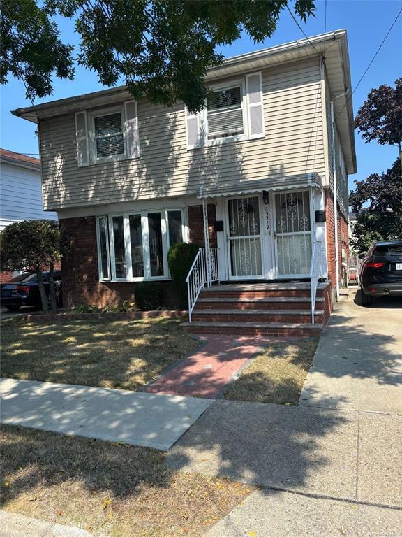 235-19 147th Drive, Unit 2 Queens, NY 11422 - Photo 1 of 6 a front view of a house with a garden