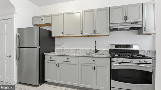 a kitchen with granite countertop white cabinets and stainless steel appliances