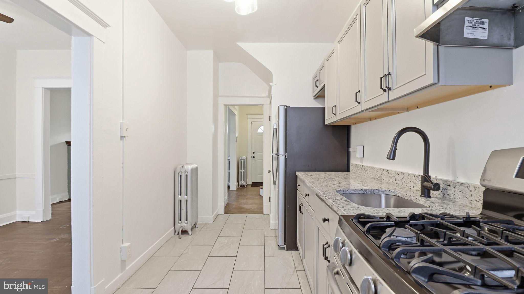 3324 Cliftmont Avenue Baltimore, MD 21213 - Photo 13 of 37 a kitchen with stainless steel appliances granite countertop a stove and a sink