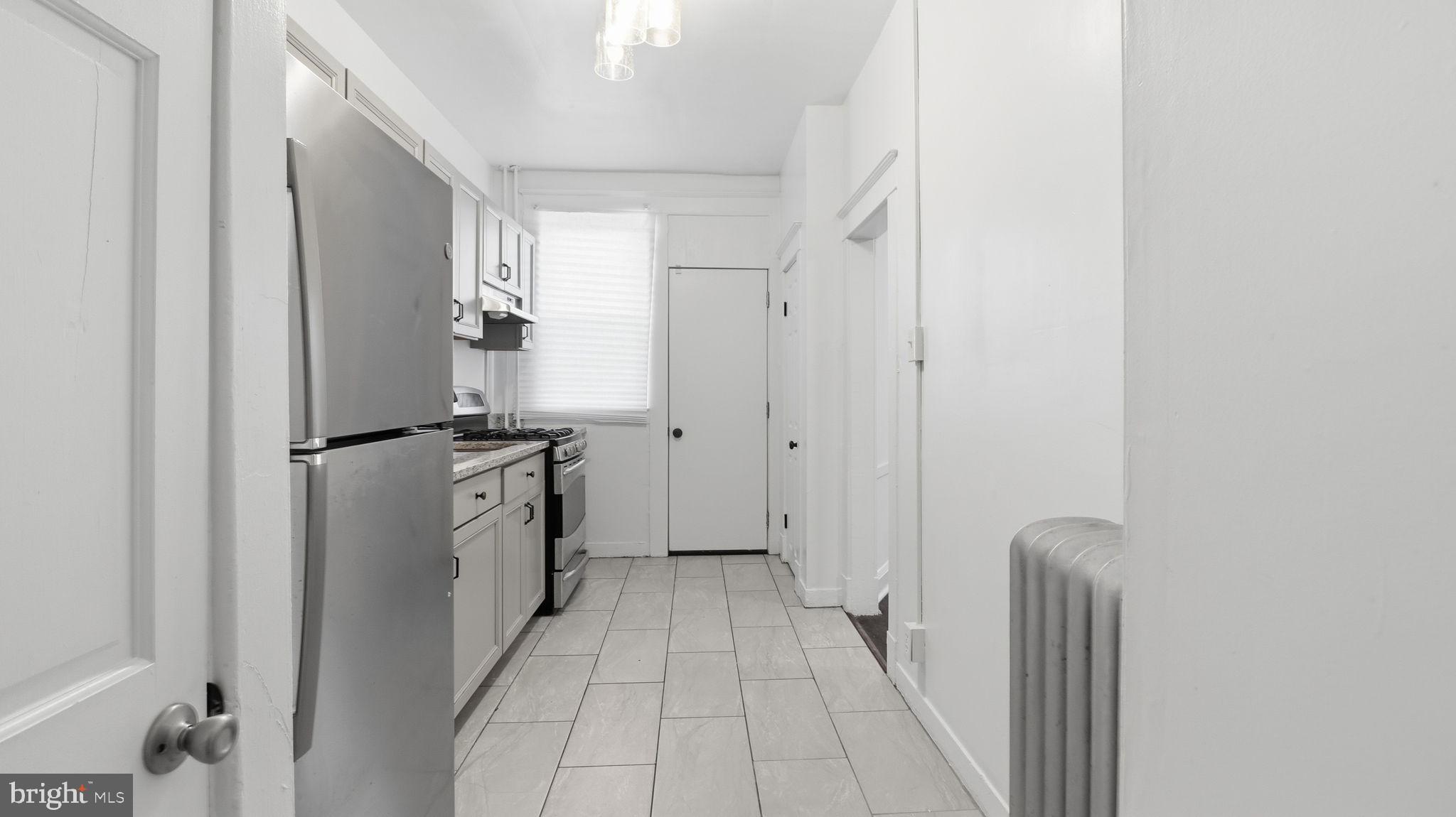 3324 Cliftmont Avenue Baltimore, MD 21213 - Photo 14 of 37 a kitchen with a refrigerator and a stove