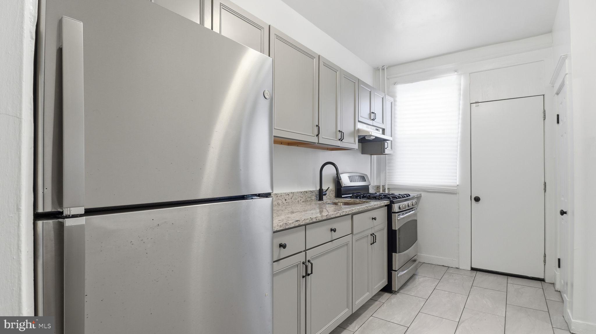 3324 Cliftmont Avenue Baltimore, MD 21213 - Photo 15 of 37 a kitchen with appliances cabinets and a window