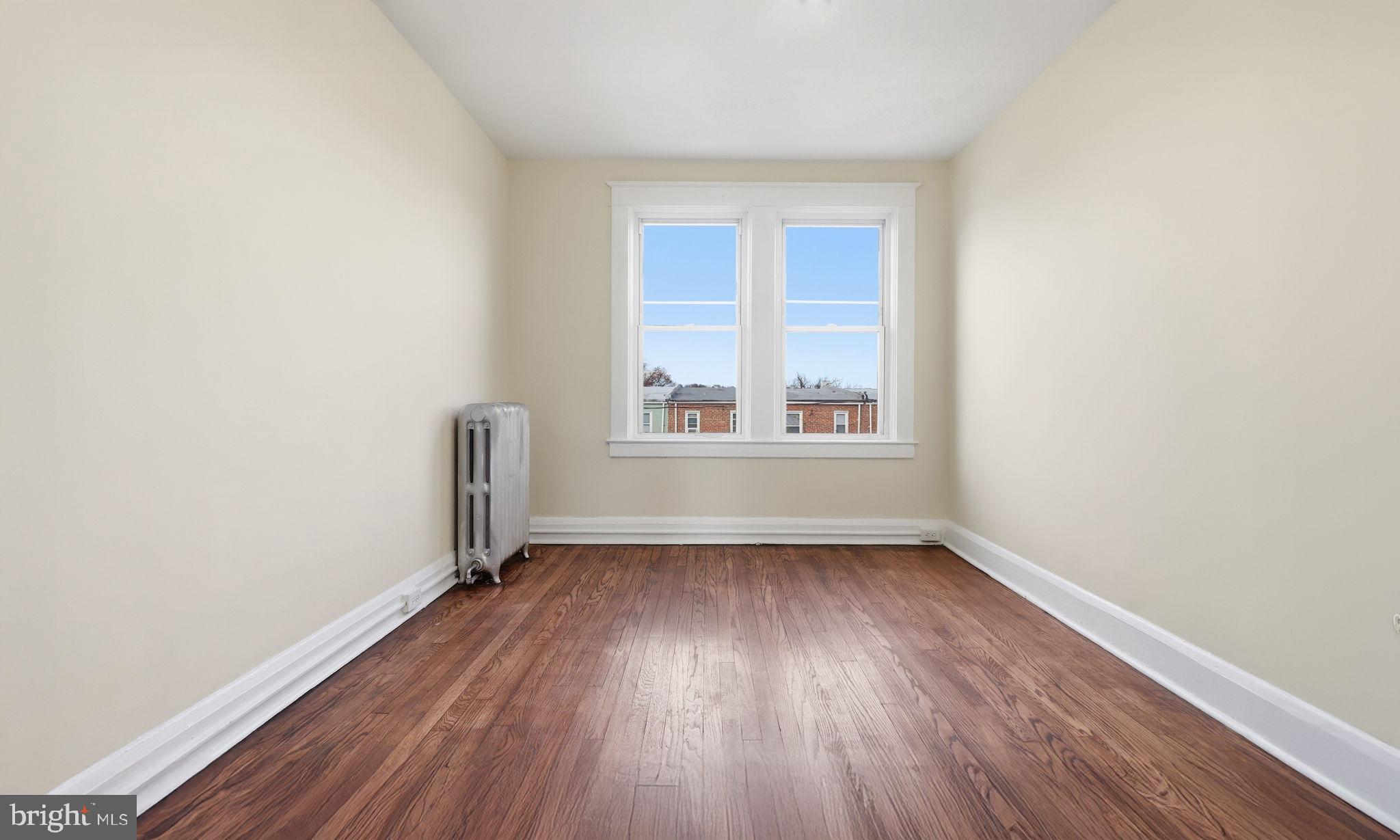 3324 Cliftmont Avenue Baltimore, MD 21213 - Photo 22 of 37 an empty room with wooden floor and windows