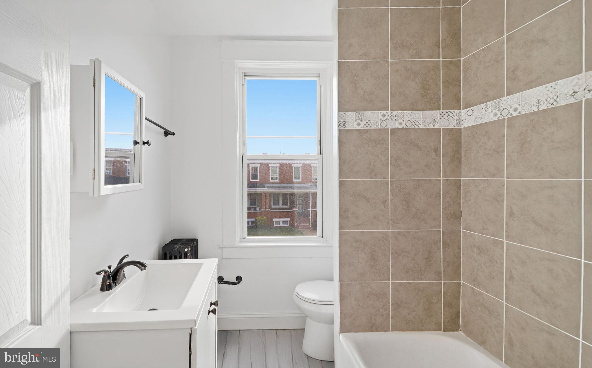 3324 Cliftmont Avenue Baltimore, MD 21213 - Photo 29 of 37 a bathroom with a sink toilet and shower