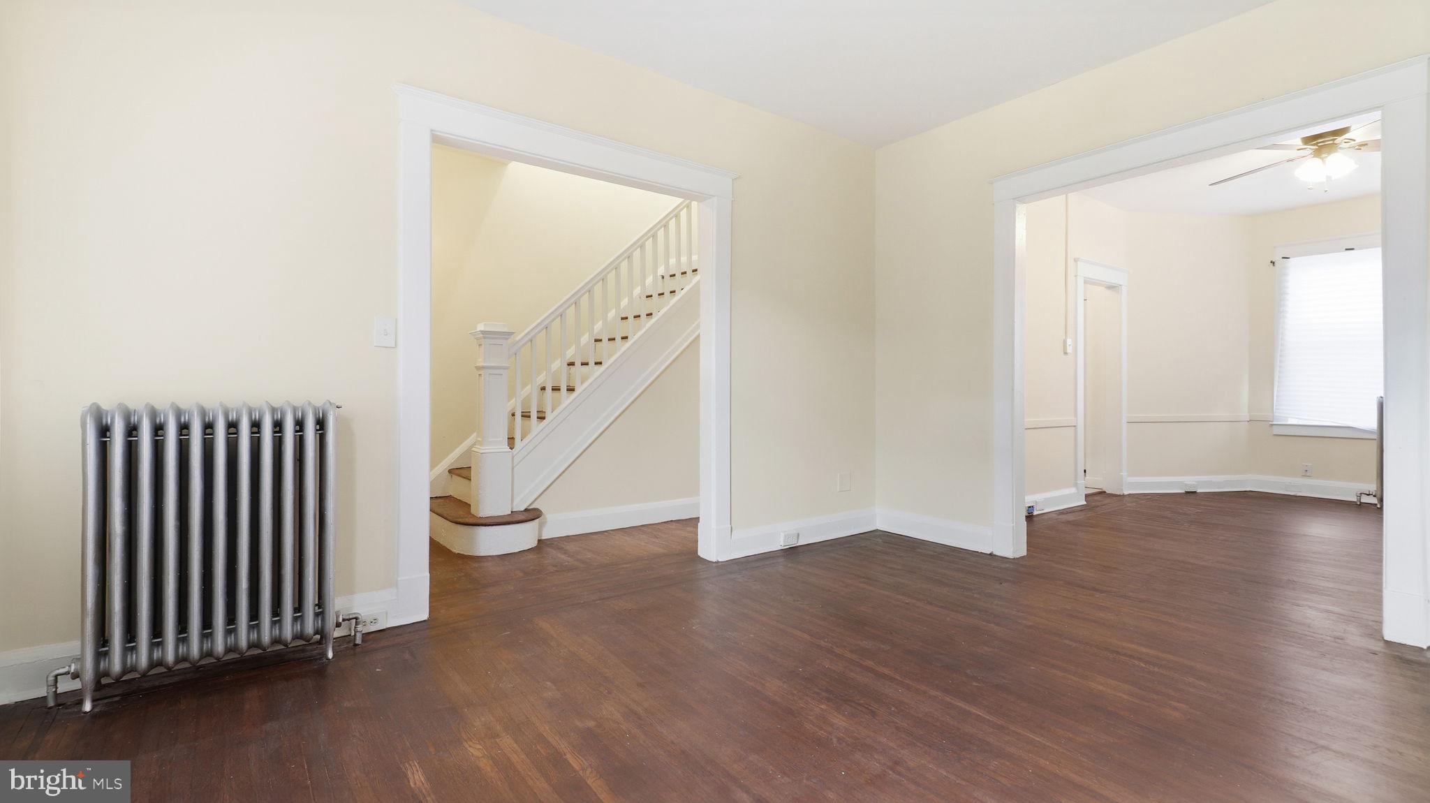 3324 Cliftmont Avenue Baltimore, MD 21213 - Photo 4 of 37 a view of an empty room with wooden floor and stairs