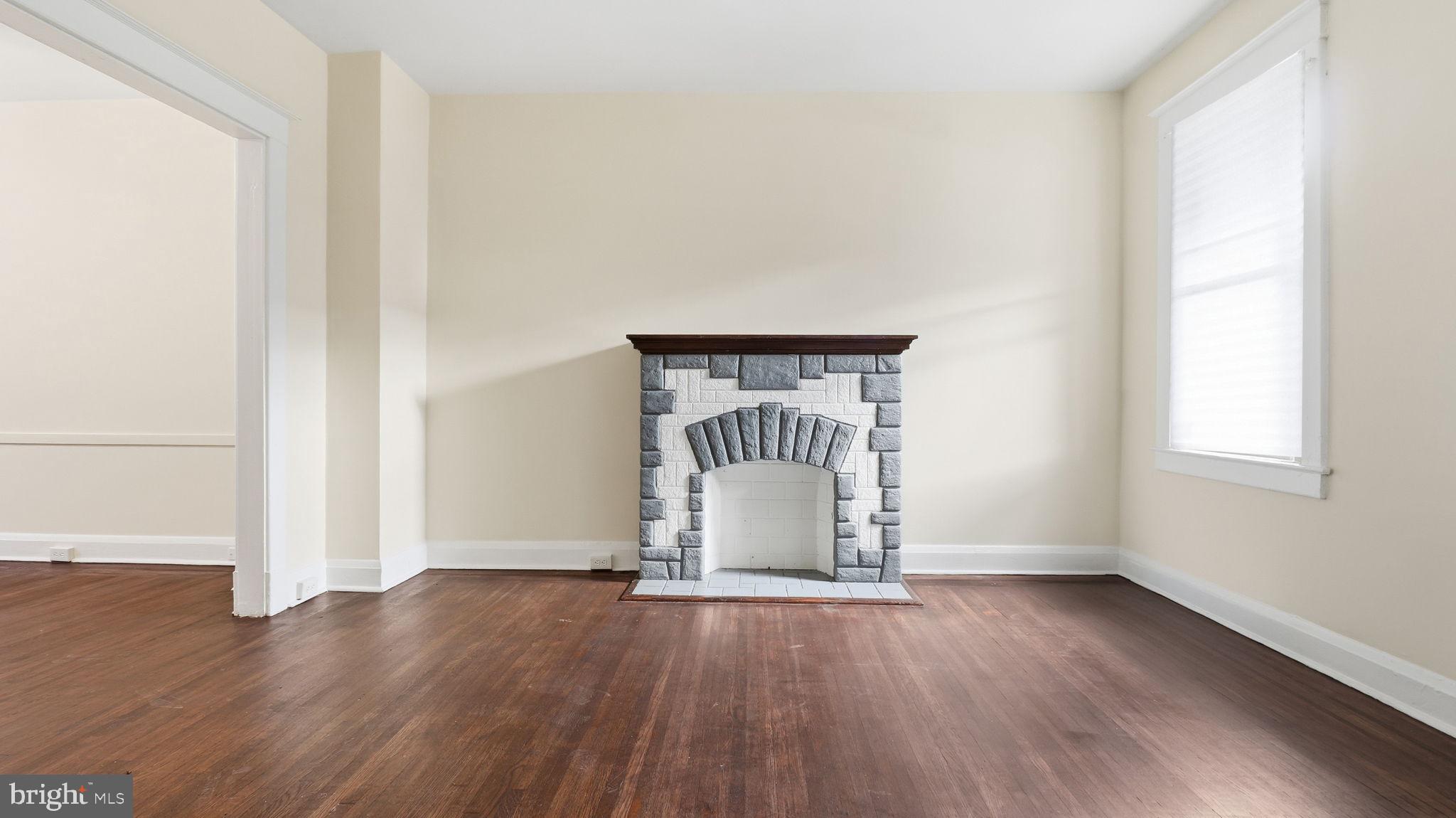 3324 Cliftmont Avenue Baltimore, MD 21213 - Photo 5 of 37 an empty room with wooden floor and windows