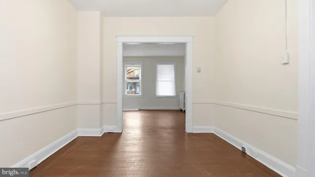 an empty room with wooden floor and a window
