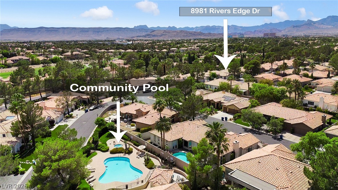 8981 Rivers Edge Drive Las Vegas, NV 89117 - Photo 58 of 69 An aerial perspective reveals a vibrant neighborhood with a community pool and serene mountain backdrop.