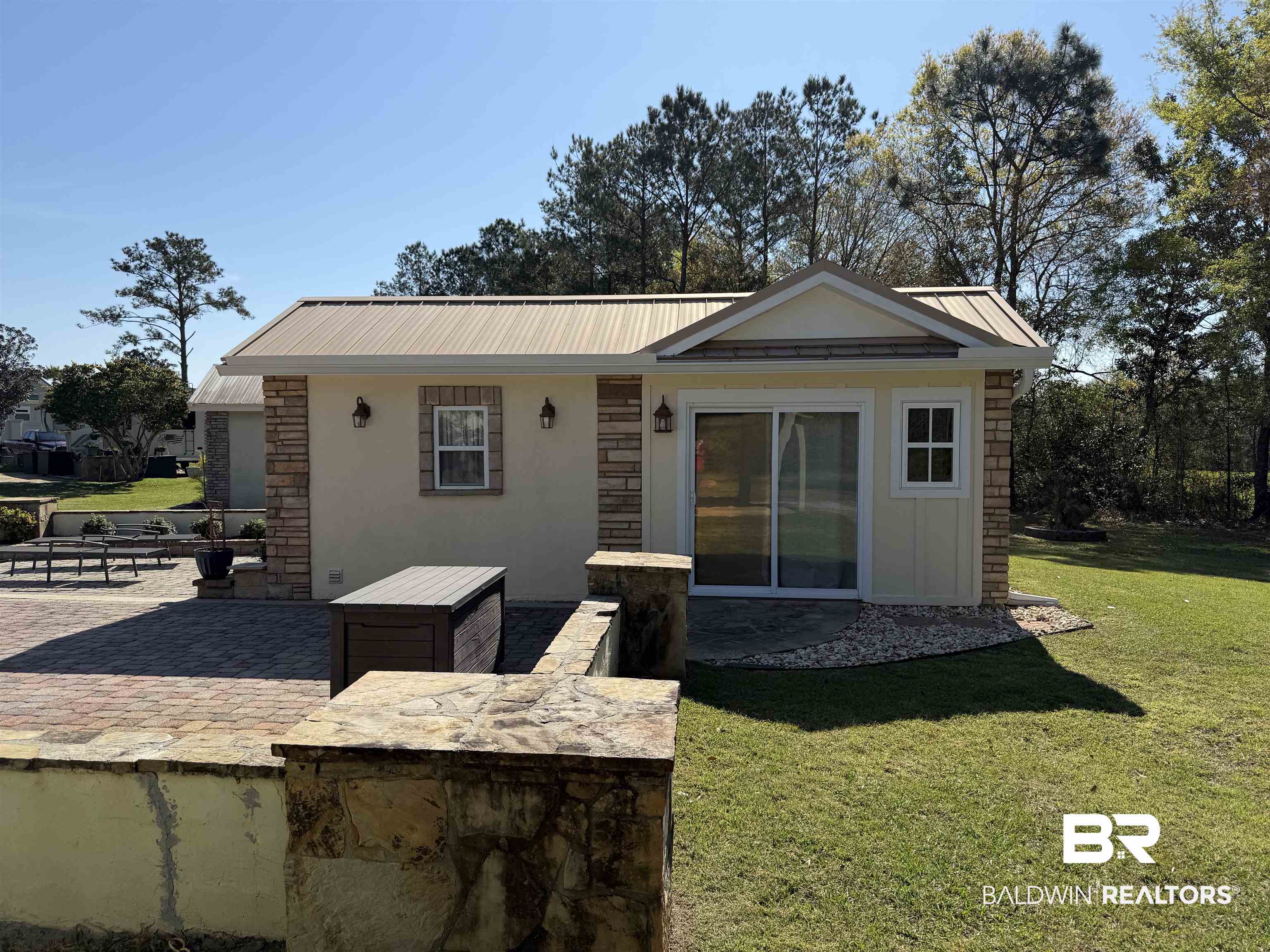 28114 Preserve Trail, Unit 190 Elberta, AL 36530 - Photo 16 of 69 Back of property featuring a patio, a yard, stone siding, a metal roof, and stucco siding