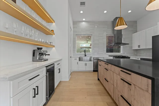 a kitchen with stainless steel appliances granite countertop a sink a stove a refrigerator a washer and dryer