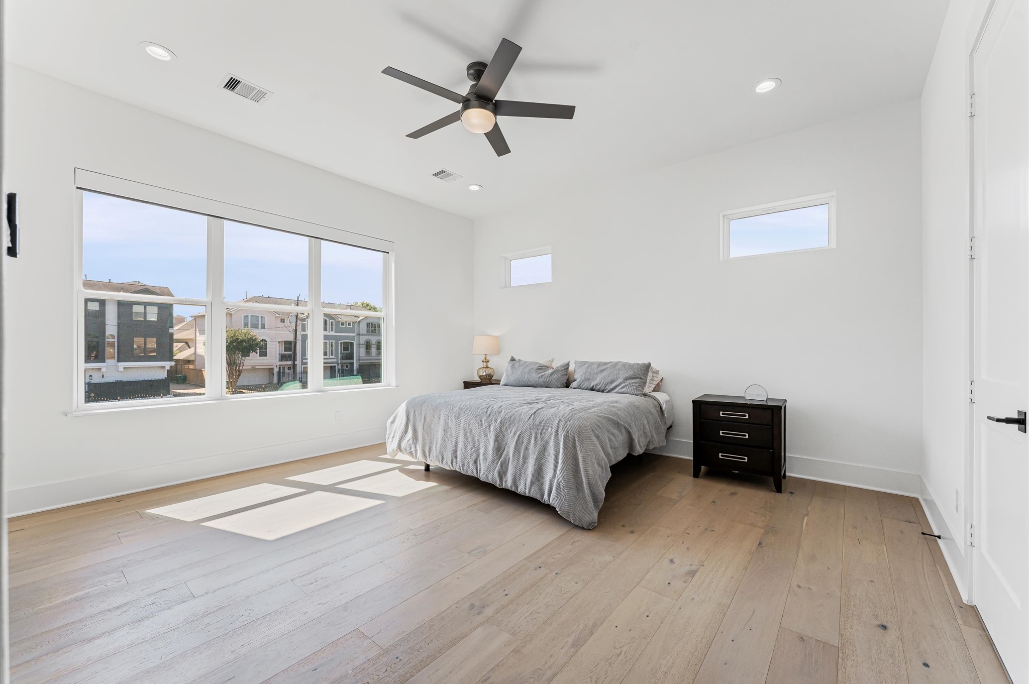711 Lester Street Houston, TX 77007 - Photo 23 of 39 a spacious bedroom with a large bed and a large window