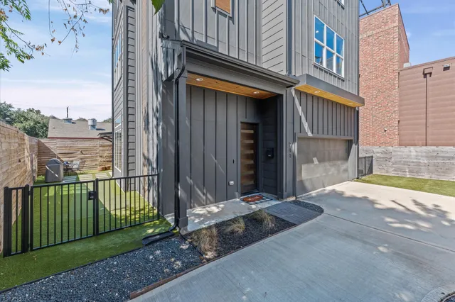 a view of a house with a floor to ceiling window and wooden fence