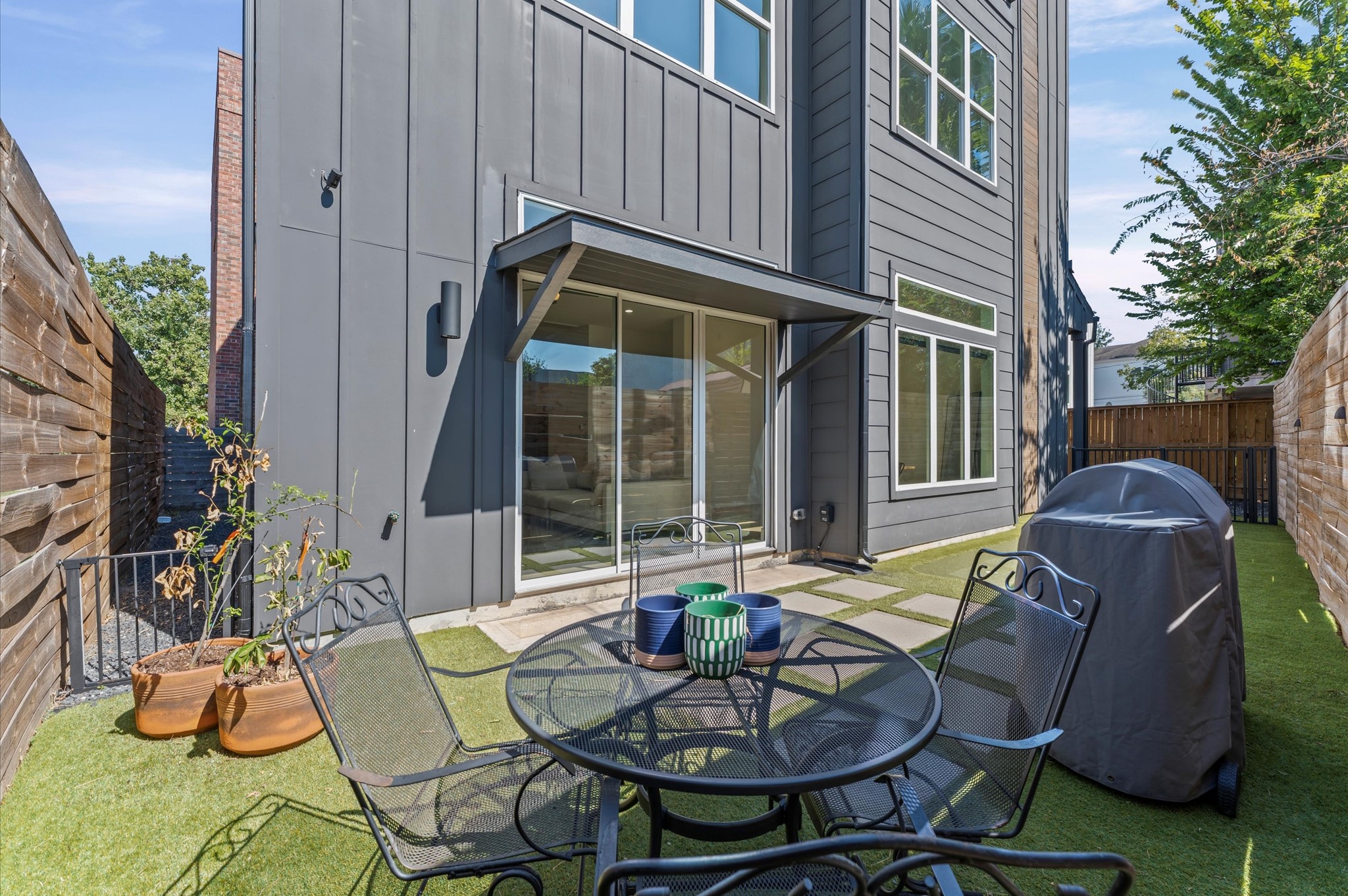 711 Lester Street Houston, TX 77007 - Photo 4 of 39 a view of a backyard with table and chairs potted plants and a building